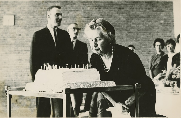 Mrs. Wilson blowing the candles on her birthday cake